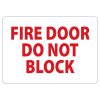 A clear sign on a fire door stating "Do Not Block" to ensure safety and compliance with fire regulations.